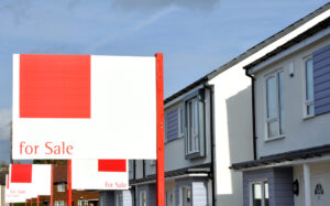 A for sale sign outside a row of houses